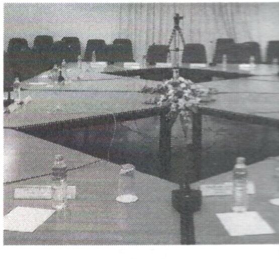 Empty committee meeting room with tables, microphones, chairs and water bottles