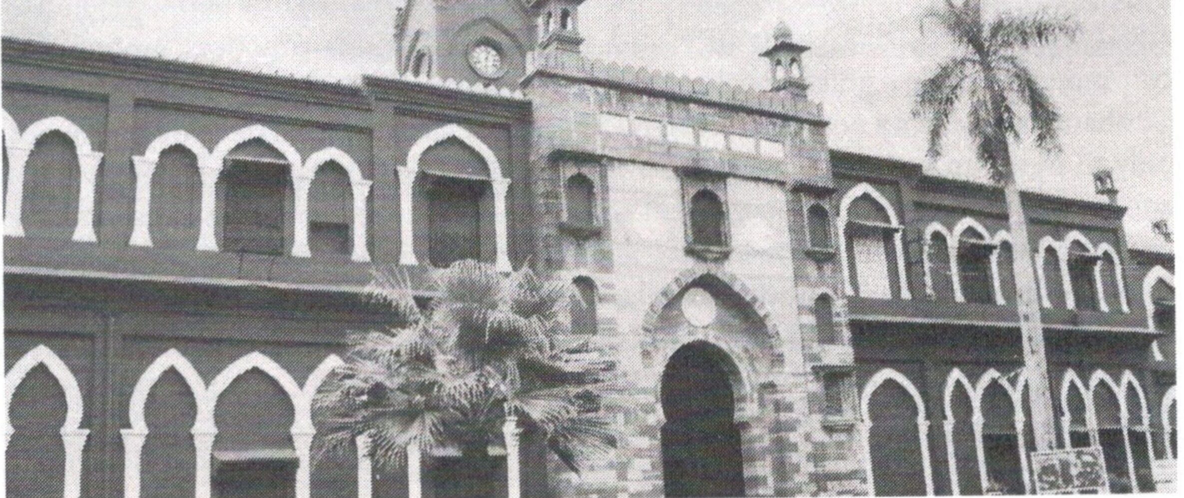 Historic institutional building with arched façade and clock tower