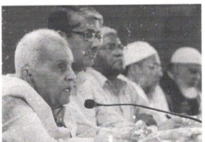 Justice Rajindar Sachar speaking into a microphone at a public meeting
